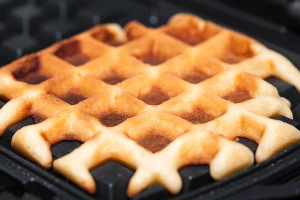 Waffles são cozidos em ferro waffle — Fotografia de Stock