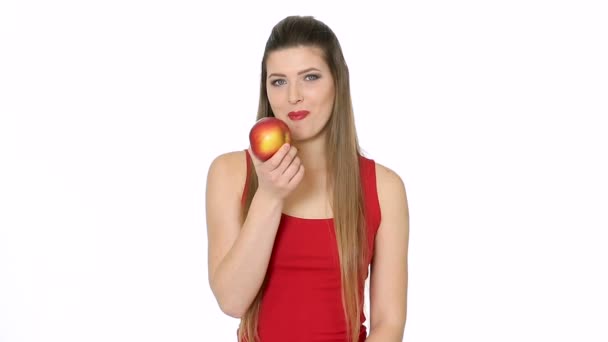 Mooi meisje eet rode appel op witte achtergrond — Stockvideo