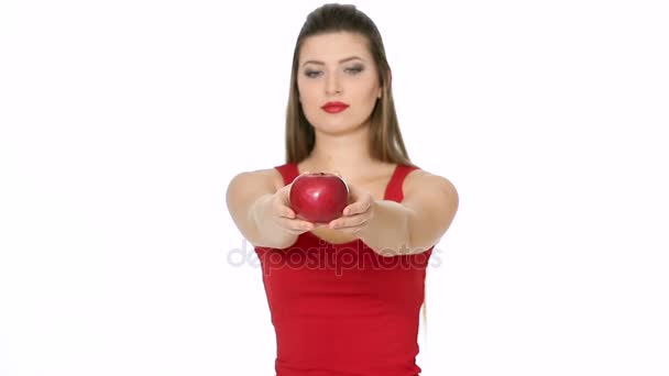 Mujer sosteniendo manzana roja y sonriendo sobre fondo blanco . — Vídeo de stock