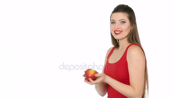 Kvinnan håller rött äpple och leende på vit bakgrund — Stockvideo