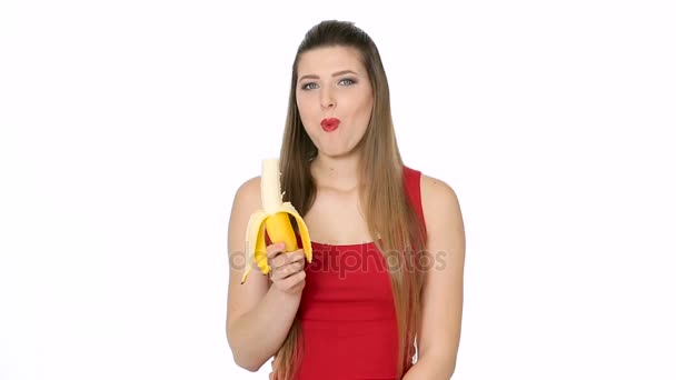 Beautiful girl eats banana on white background — Stock Video