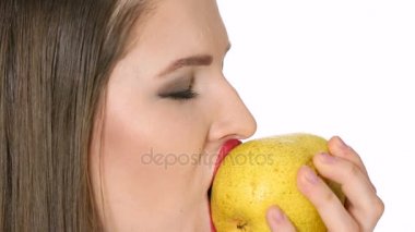 güzel kız olgun armut beyaz arka plan üzerinde yiyor.