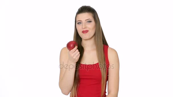 Hermosa chica come manzana roja sobre fondo blanco — Vídeos de Stock