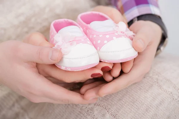 Botines rosados para bebé recién nacido en manos de mamá y papá. embarazo — Foto de Stock
