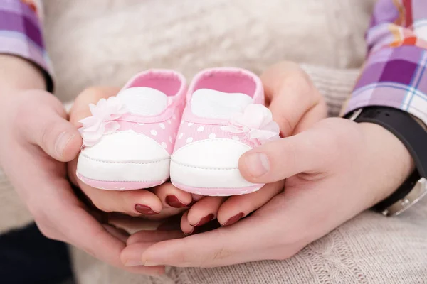 Botines rosados para bebé recién nacido en manos de mamá y papá. embarazo — Foto de Stock