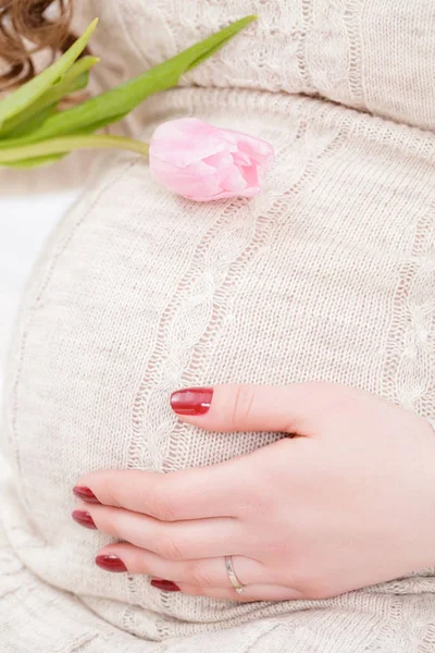 Primer plano de la mujer embarazada con tulipanes toque su campana — Foto de Stock