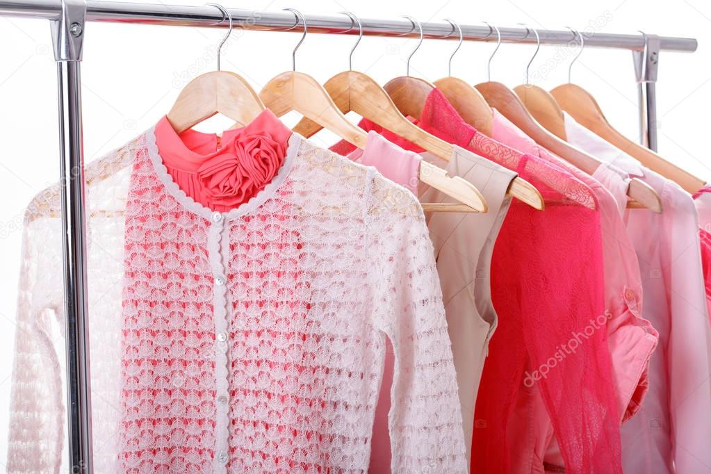 pink womens clothes on hangers on rack on white background. clos