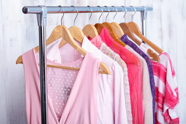 Roupa de mulher rosa em cabides em tortura na loja de moda. armário — Fotografia de Stock