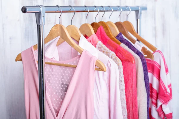 Pinkfarbene Frauenkleidung auf Kleiderbügeln im Modegeschäft. Kleiderschrank — Stockfoto