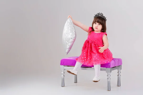 Linda menina em vestido de princesa rosa com coroa sentada — Fotografia de Stock