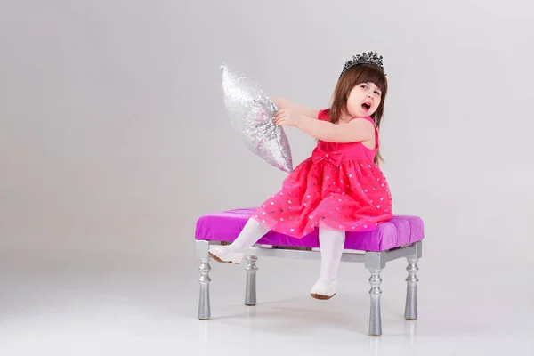 Красива маленька дівчинка в рожевій сукні принцеси з короною сидить — стокове фото