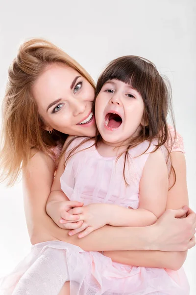 Портрет блондинки мама и милая маленькая дочь в розовых платьях — стоковое фото
