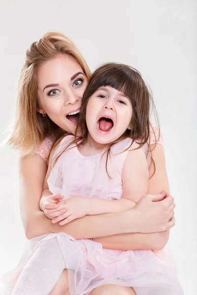 Szőke anyu és édes kislányom, rózsaszín ruhákat portréja — Stock Fotó