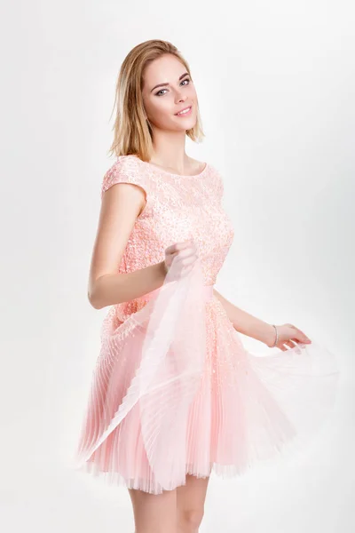 Schöne blonde Frau in einem rosa Cocktailkleid tanzen und havin — Stockfoto