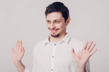 genç gülümseyen çekici esmer gri bac üzerinde Beyaz tişörtlü adam