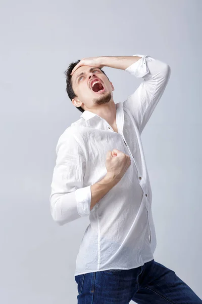 Retrato de hombre joven con el pelo oscuro en camisa levanta las manos un — Foto de Stock