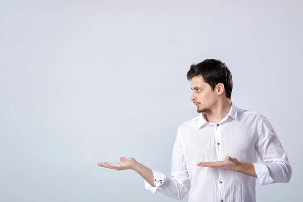 Retrato de jovem com cabelo escuro em camisa branca aparece em — Fotografia de Stock