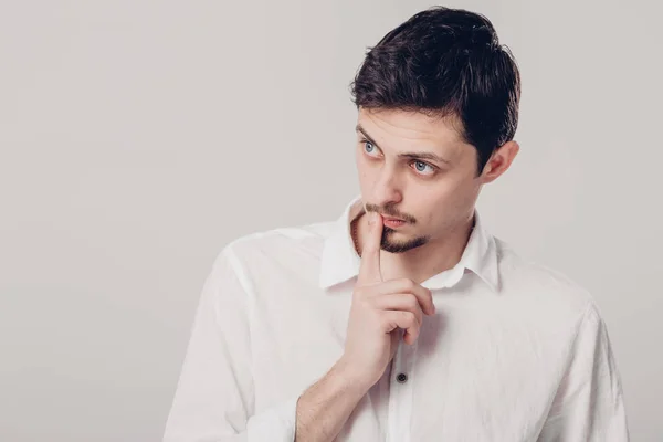 Portrait de beau jeune homme songeur en chemise blanche sur ba gris — Photo