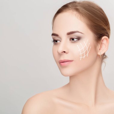 Gri arka plan üzerinde yüzünde oklarla kadın portresi Spa