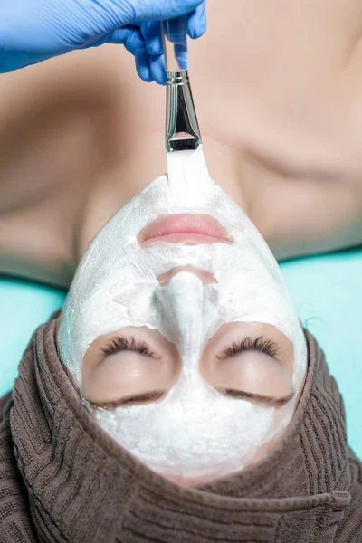 Şevval Özçelik Güzellik Spa salonda genç kadındaki yüz maskesi uygular. cosmet — Stok fotoğraf