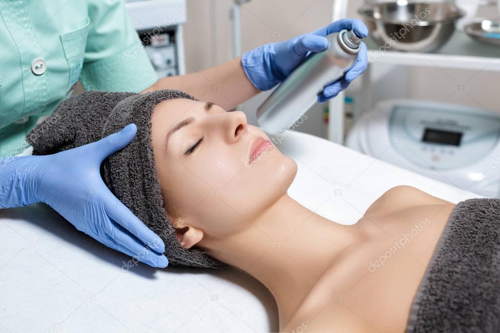 beautician uses facial spray. beautician uses facial spray in Spa salon. cosmetic procedure skin care. Microdermabrasion