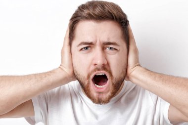 Siyah saçlı ve sakallı t-shirt ile kızgın genç adam bağırır bir