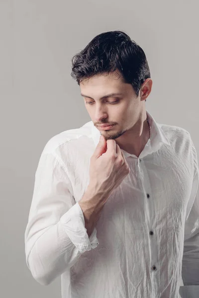 Portret van de knappe jongeman met donker haar in wit overhemd op — Stockfoto