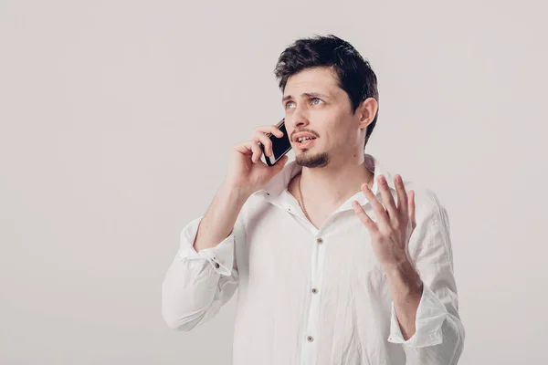 Ritratto di attraente giovane bruna uomo in camicia parlando su sm — Foto Stock