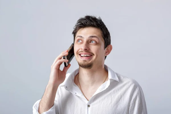 Retrato de atraente jovem morena homem na camisa falando sobre sm — Fotografia de Stock