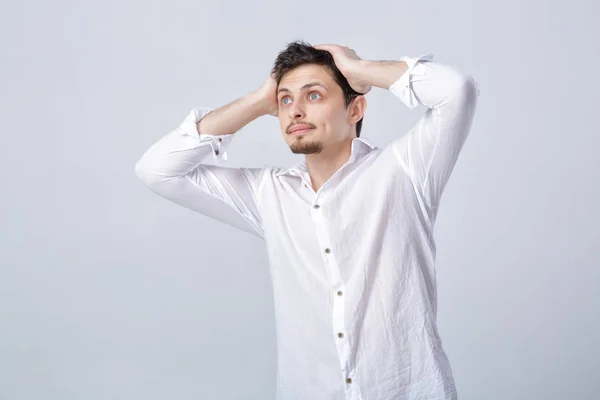 Jeune homme brune attrayant surpris en chemise blanche sur gris b — Photo