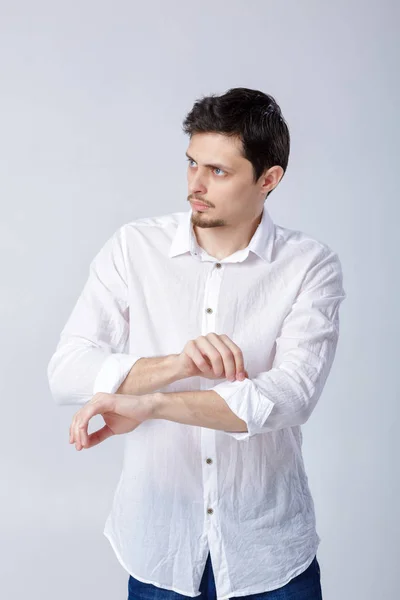 Портрет привлекательного брюнетки мужчина в белой рубашке регулировки его — стоковое фото