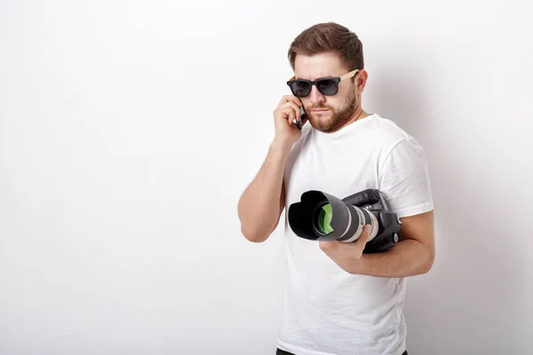 Jeune photographe professionnel en chemise blanche tient caméra numérique — Photo
