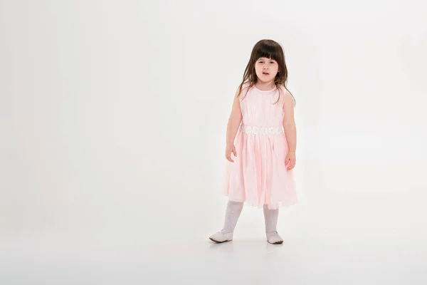 Красива маленька дівчинка в рожевій сукні принцеси на сірому фоні — стокове фото