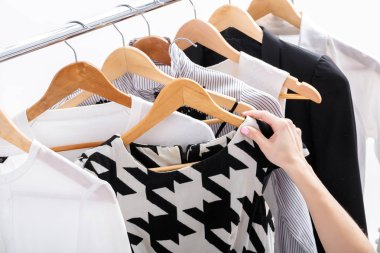 el raf ahşap askı üzerinde yeni moda giysiler seçer,