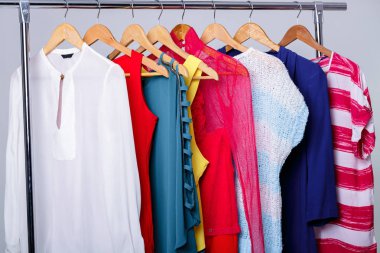 Askı raf gri arka plan üzerinde renkli bayan elbise. w