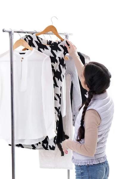 Kvinnan väljer nya Modekläder på trä galgar på rack. Shopp — Stockfoto