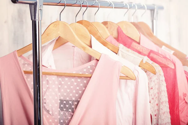 Roupa de mulher rosa em cabides em tortura na loja de moda. armário — Fotografia de Stock