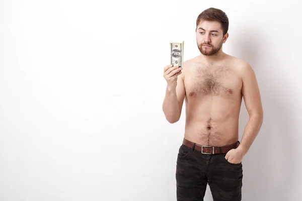 Joven hombre guapo con barba sosteniendo un montón de billetes de cien dólares. dinero . — Foto de Stock