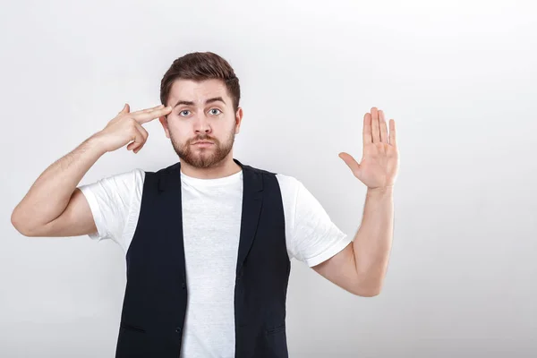 Dito al suo tempio. giovane uomo con la barba in camicia e gilet tiro con il dito sulla testa . — Foto Stock