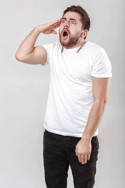 Jovem homem bonito com barba em t-shirt ouvindo música em fones de ouvido — Fotografia de Stock