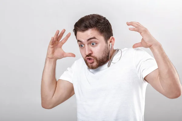Jonge knappe man met baard in t-shirt luisteren naar muziek op koptelefoon — Stockfoto
