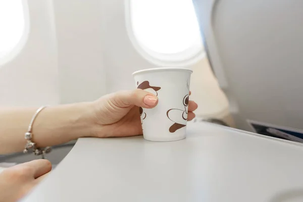 Frau trinkt Kaffee im Flugzeug. — Stockfoto