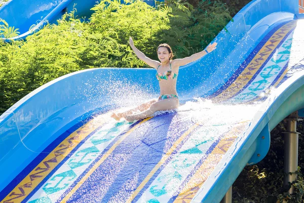 Frau stürzt eine Wasserrutsche hinunter — Stockfoto