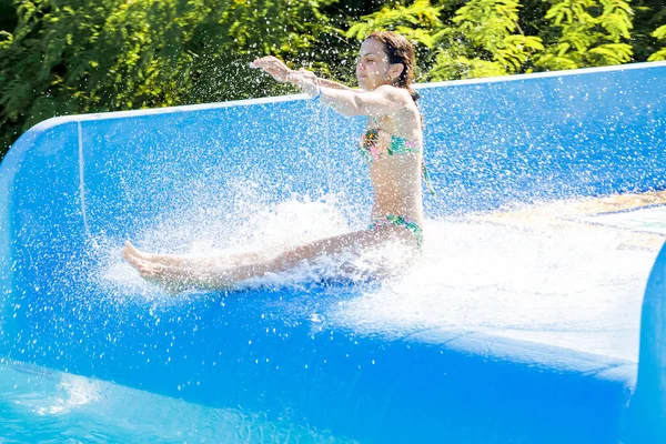 Mujer bajando por un tobogán acuático — Foto de Stock