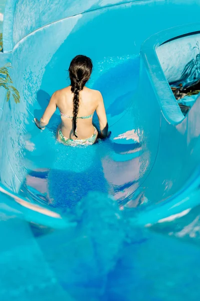 Mujer bajando por un tobogán acuático — Foto de Stock