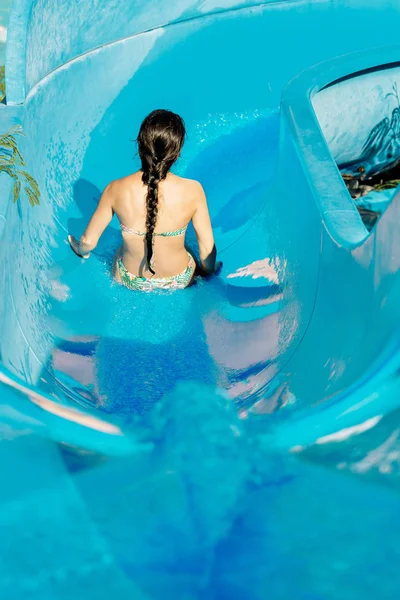 Vrouw die naar beneden een waterglijbaan — Stockfoto