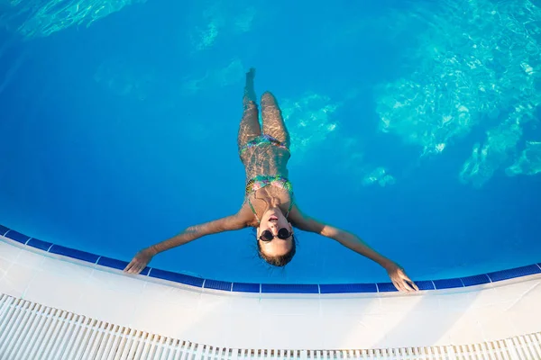 Vrouw ontspannen in blauwe zwembad. — Stockfoto