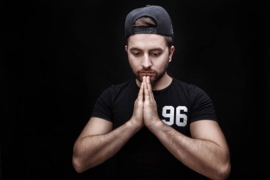 yoga poz siyah arka plan üzerine portresi ile siyah saçlı giyen genç çekici adam siyah gömlek.