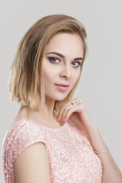 Portrait of beautiful blond sensual woman in pink cocktail dress on grey background — Stock Photo, Image