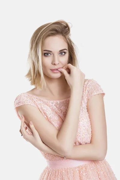 Portret van mooie blonde sensuele vrouw in roze cocktail jurk op grijze achtergrond — Stockfoto